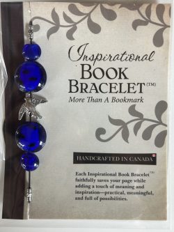 Packaged Inspirational Book Bracelet featuring rich cobalt blue disc beads, blue sphere accents, and a central silver songbird charm mounted on a branded backing card.