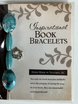 Packaged Inspirational Book Bracelet featuring mottled turquoise stone oval beads, tubular turquoise accent beads, and a dangling silver dolphin circle charm mounted on a branded backing card.
