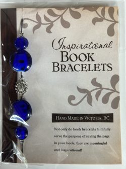 Packaged Inspirational Book Bracelet featuring rich cobalt blue disc beads, blue sphere accents, and a central silver sunflower spacer mounted on a branded backing card.